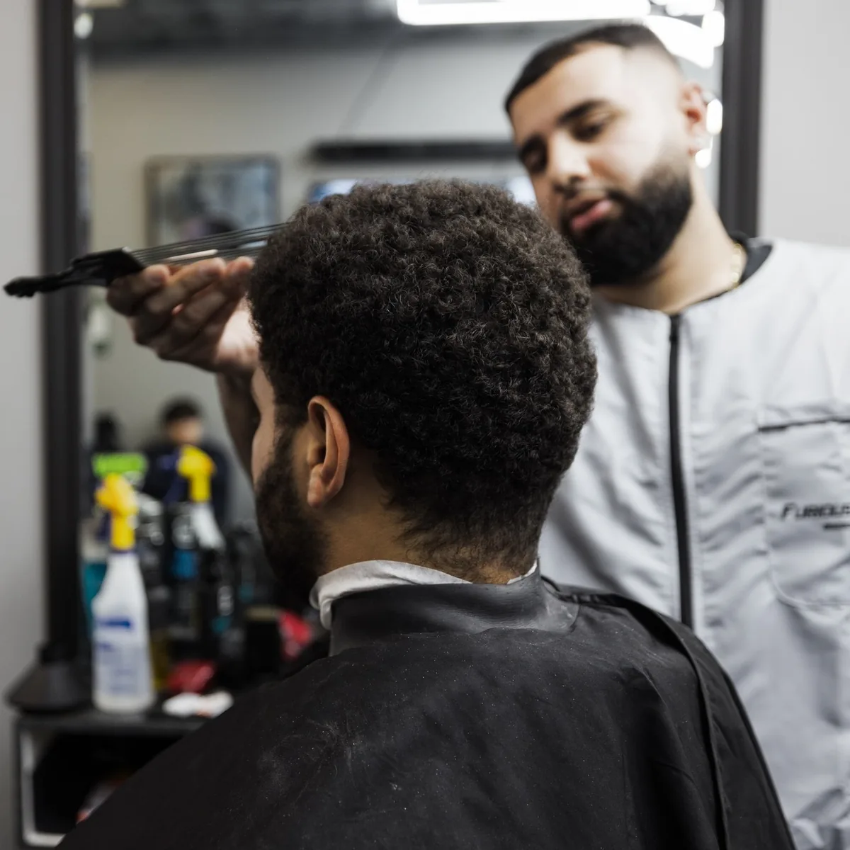 Furious Fades barber cutting a client's curly hair