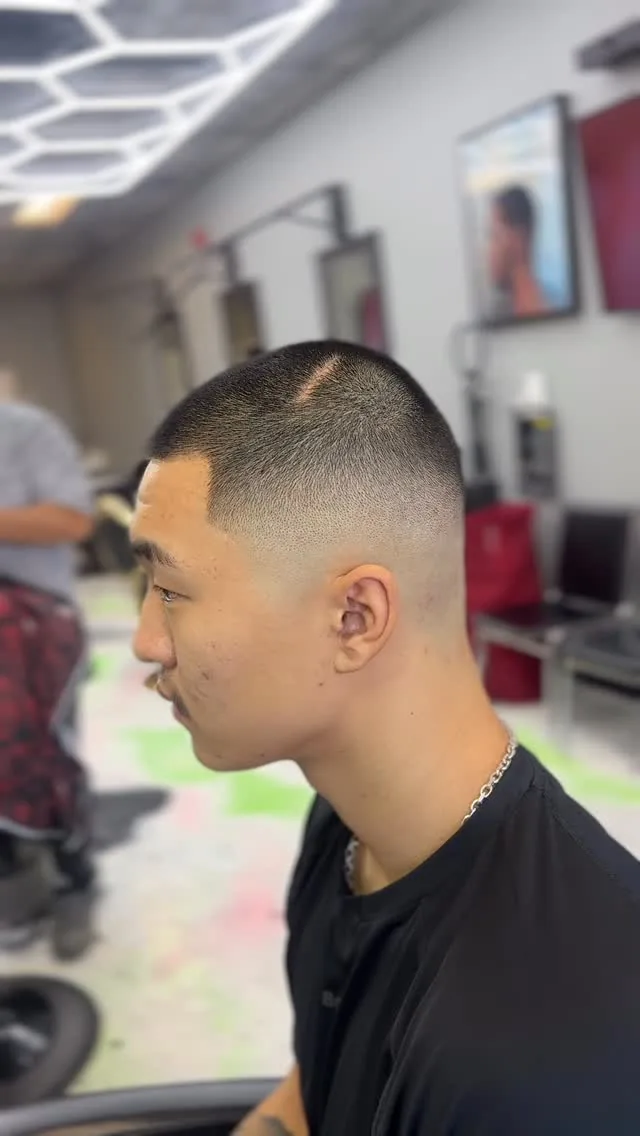 Buzz cut with a high skin fade and sharp line-up, side profile