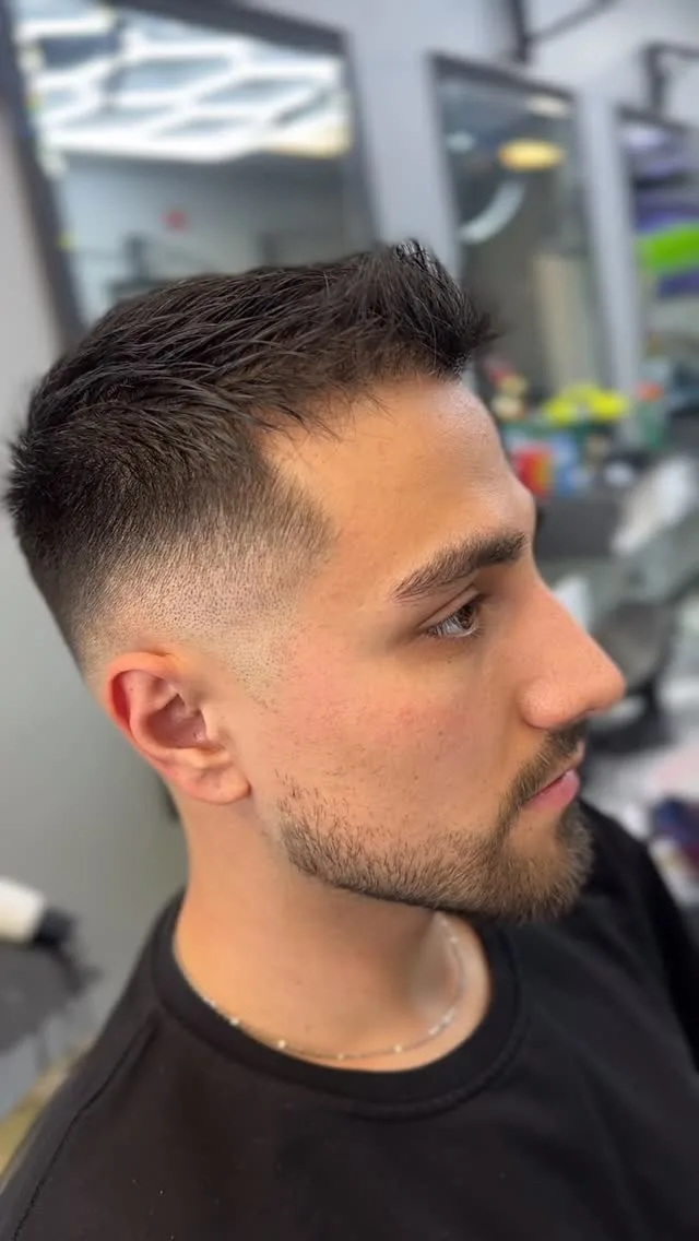 Low skin fade with a textured top and trimmed beard, side profile, at Furious Fades Richmond Hill