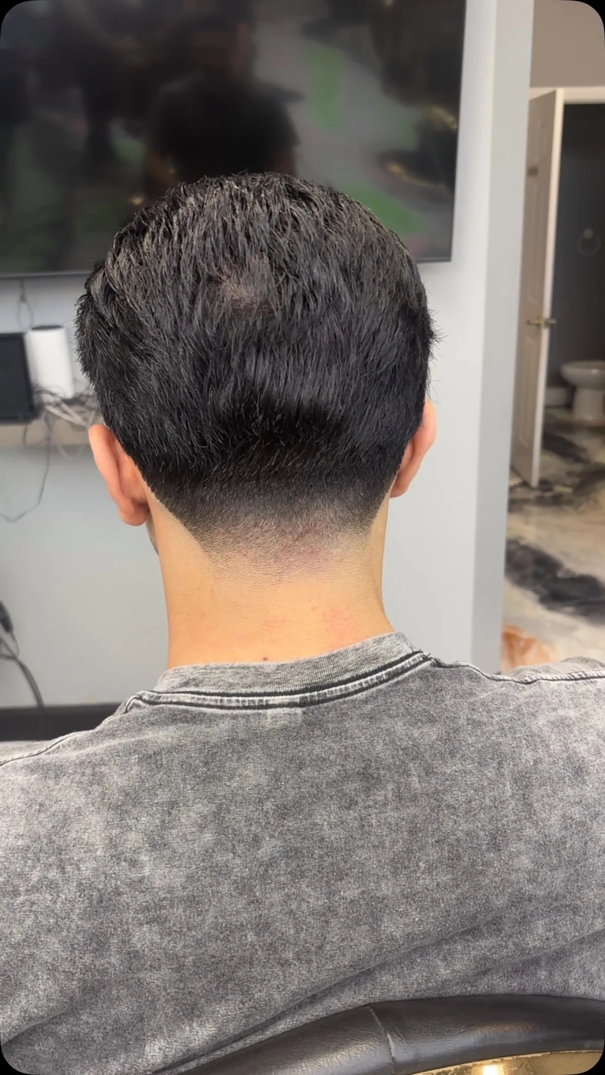 Back view of a taper neckline on thick dark hair